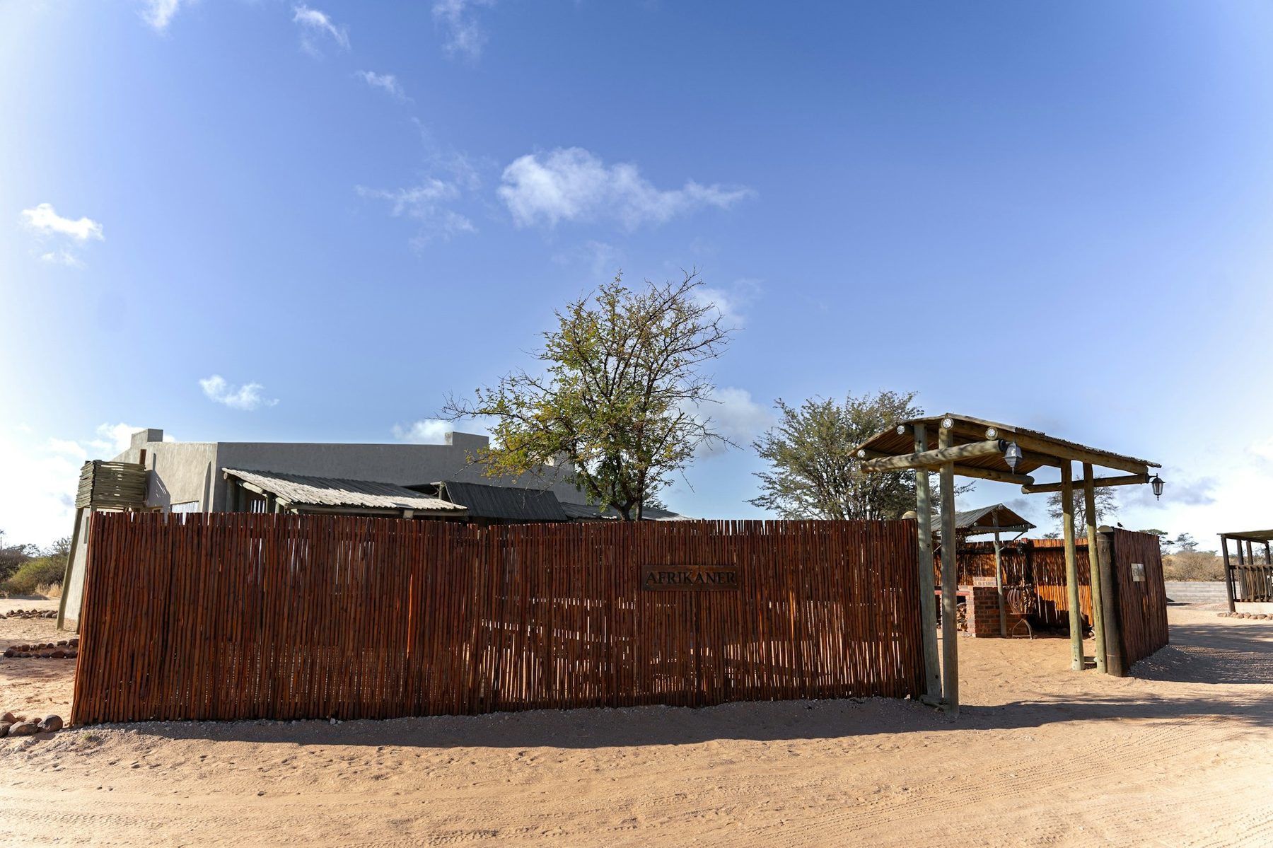 The camp entrance in dappled shade