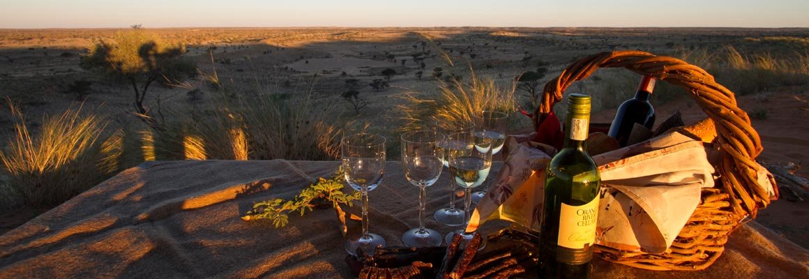 Sundowner picnic set out on the dune crest
